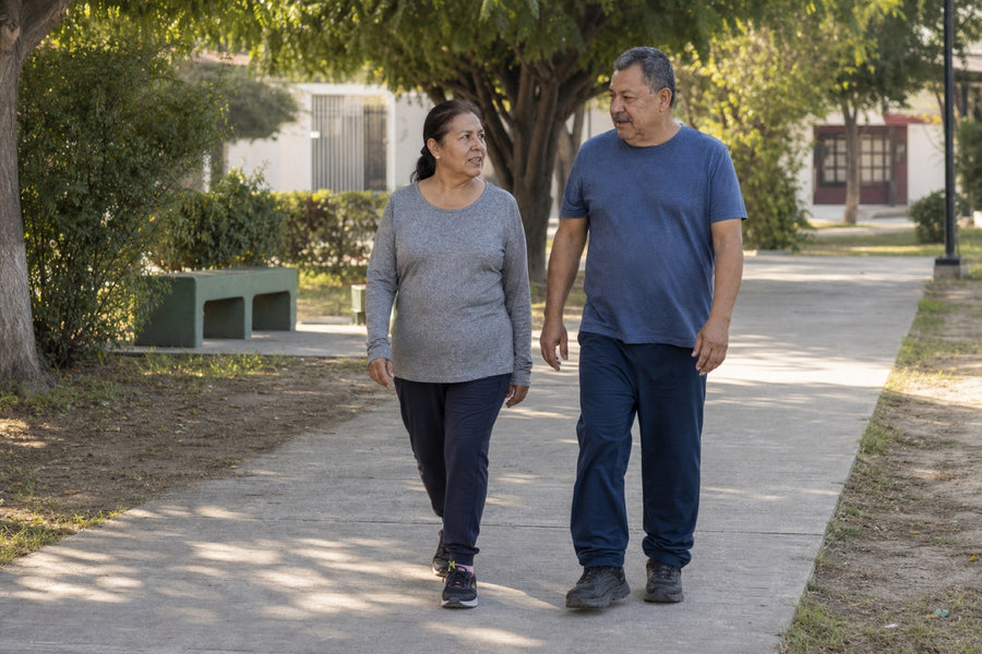 Pareja adulta caminando y conversando en un parque de barrio
